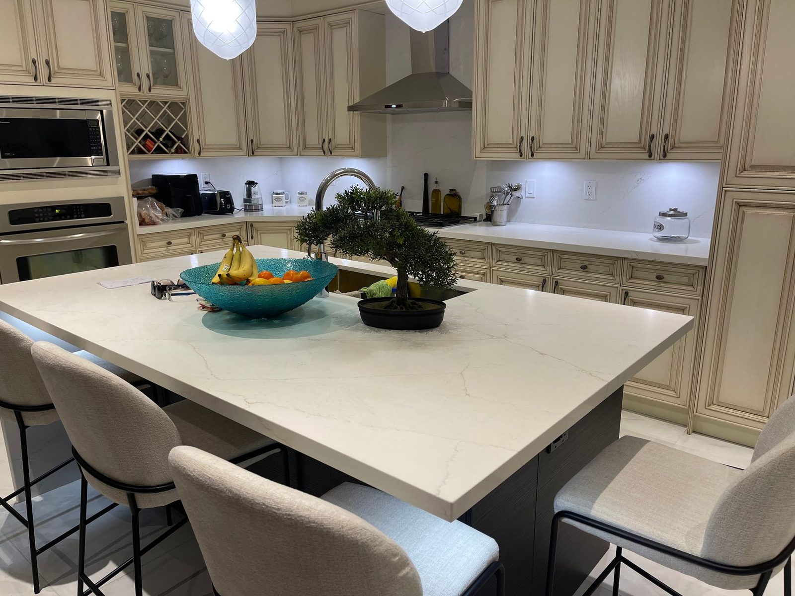 Custom kitchen with cream cabinets, large island, counter stools and pendant lights