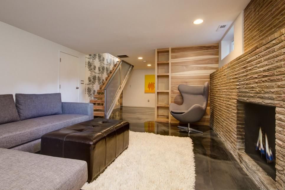 Basement living room with stone fireplace, wood accent wall and a sculptural egg chair